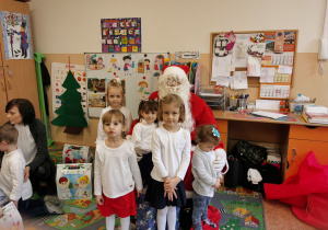 Dziewczynki pozują do zdjęcia z Mikołajem.