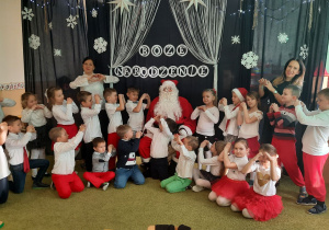 Dzieci pozują do zdjęcia z Mikołajem.