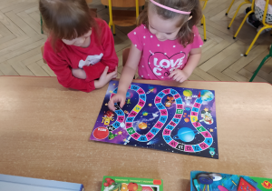 Dziewczynki grają przy stoliku.