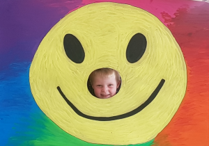 Dziecko w fotobudce z uśmiechem.