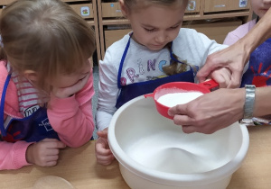 Dzieci przesiewają mąkę.
