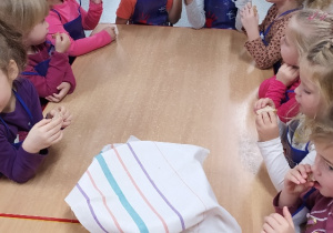 Dzieci siedzą i obserwują jak rośnie chleb.