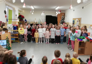 Dzieci śpiewają piosenkę o Mikołaju.