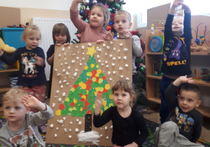 Dzieci prezentują wspólną pracę plastyczną.