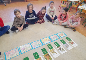 Dzieci na dywanie uczą się liczyć.