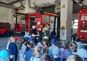 Dzieci oglądają samochody strażackie.