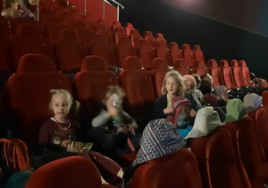 Dzieci w kinie szykują się na seans.