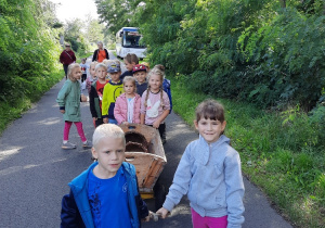 Dzieci ciągną wóz na pole.