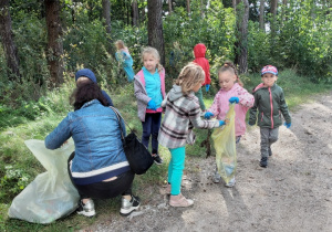Dzieci sprzątają okolice swojego przedszkola w ramach Sprzątania Świata.