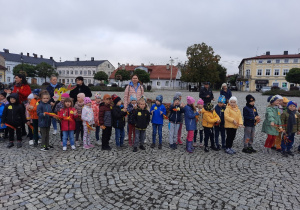 Dzieci świętują Dzień Przedszkolaka na placu, tańcząc i śpiewając.