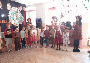 Dzieci stoją w półkole i śpiewają piosenkę.