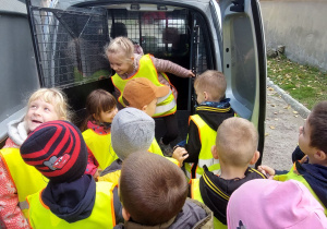 Dzieci oglądają policyjny samochód.