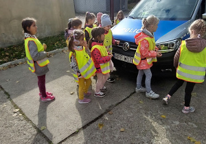 Dzieci oglądają policyjny samochód.