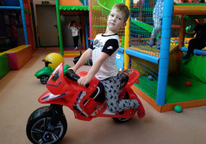 Chłopiec na motorze zabawkowym.