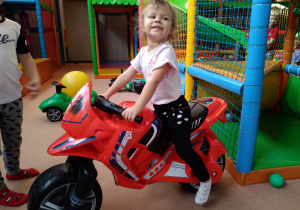 Dziewczynka na motorze zabawkowym.