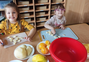 Dzieci robią sałatkę owocową.