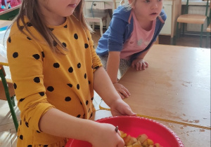 Dzieci robią sałatkę owocową.