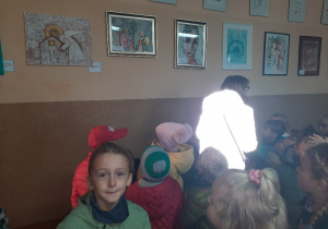 Dzieci oglądają dzieła malarskie na wystawie.