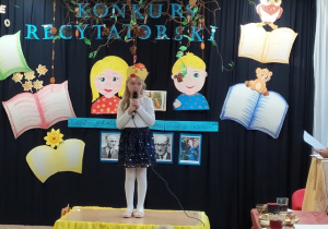 Dziewczynka deklamuje wiersz na małej scenie.