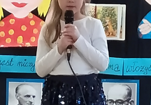 Dziewczynka deklamuje wiersz na małej scenie.