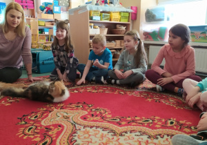 Dzieci słuchają prelekcji o kotach.