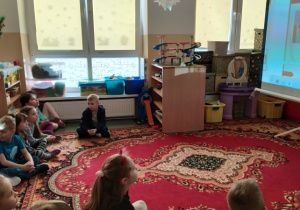 Dzieci słuchają prelekcji o kotach.