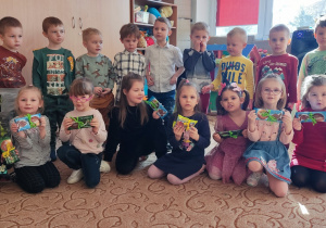Zdjęcie grupowe chłopców i dziewczynek, które trzymają czekolady dla chłopców z okazji ich święta.