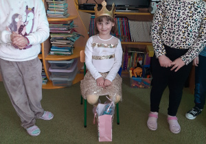 Jubilatka Kornelia w koronie siedzi na ktrzesełku.