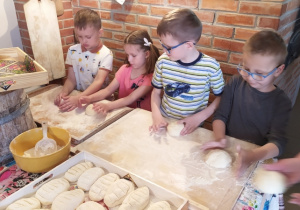 Dzieci wyrabiają chleb.