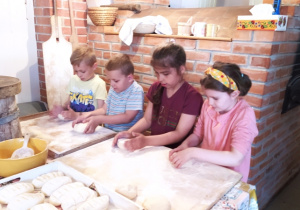 Dzieci wyrabiają chleb.