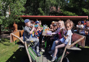 Dzieci spożywają posiłek na wozie.