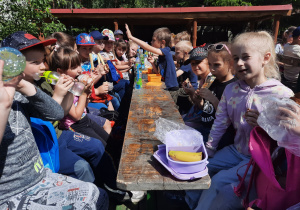 Dzieci spożywają posiłek na wozie.