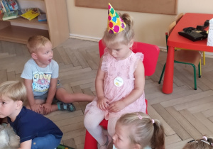 Dziewczynka świętuje swoje urodziny w grupie dzieci.