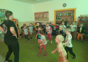 Dzieci wraz z panią tańczą do dziecięcych utworów.