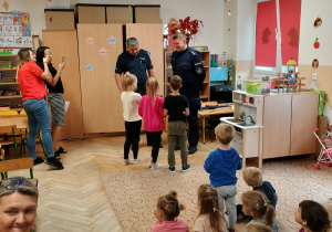Dzieci słuchają prelekcji policjanta.