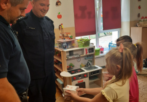 Dzieci wręczają podziękowania panom policjantom.
