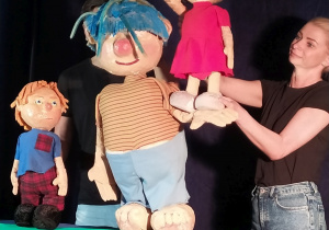 Aktorzy manipulują lalkami w teatrzyku.
